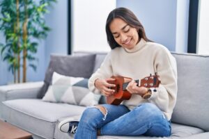 adult playing a ukulele. 